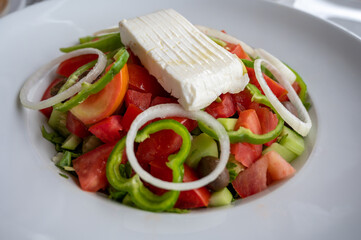 Summer healthy food, vegetable greek salad made with fresh cucumber, tomatoes, onion, feta cheese, green paprika and olives