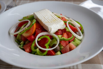Summer healthy food, vegetable greek salad made with fresh cucumber, tomatoes, onion, feta cheese, green paprika and olives