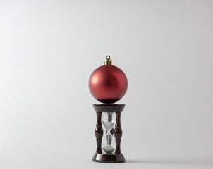 Christmas ball and hourglass on a white background. New Year's concept