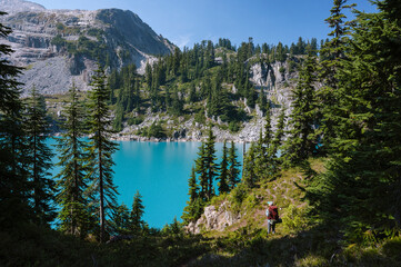 Female standing next to magical alpine lake in the cascades