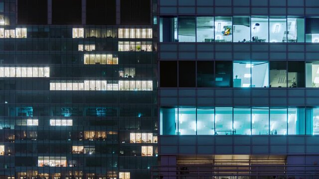 Time lapse office windows lights in business center building facade, people working late night. Corporate business, high skyscraper glass surface. Light in building windows turn on and off