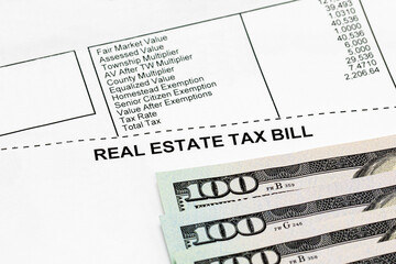 Real estate property tax bill with 100 dollar bills. school funding, taxes, debt, and local...