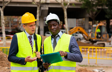 Portrait of an engineer and architect with folder of documents at a construction site