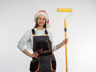 Girl builder with roller brush. Contented woman repairman. Christmas renovation. Woman in santa...