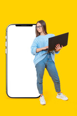 Take advantage of new application. Happy woman student with laptop. Girl in front of big phone. Smartphone template for application demonstration. Educational application. Big phone on yellow