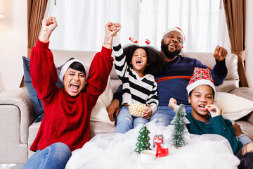 Happy family has fun sitting together on the sofa at home. cheerful young family with children laughing. African American family