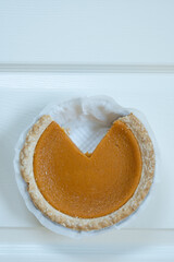 Vertical shot of pumpkin pie on white background