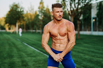 athletic man with pumped up muscular body in the park exercise workout motivation