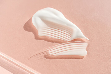 The texture of the white cream on a pink background.