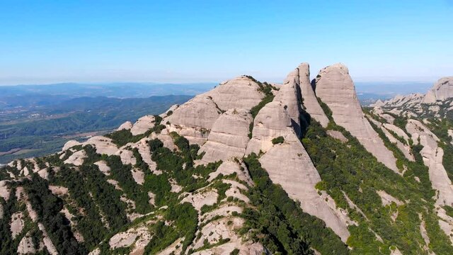 Aerial: Montserrat mountain range from the air in a sunny day