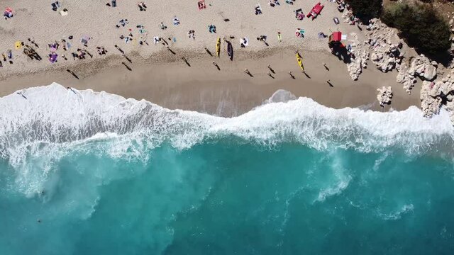 hustle and bustle at the breathtakingly beautiful bay of cala luna with violent waves, bird's eye view with drone, in sardinia
