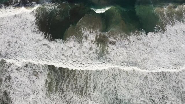 big waves swirl sand in the clear turquoise water on the sandy beach of rena majore (sardinia)