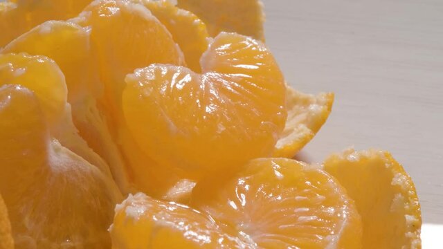 Extreme Macro shot juicy mandarin slices to green Vegetation foreground - Dolly Motion