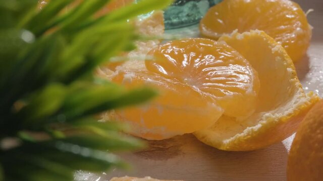 Close up Textured peeled fresh mandarin surface juice glass, Tilt up Slow motion 