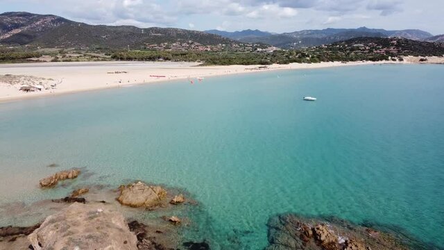 perfect picture book beach in south sardinia in chia with 2 rocks in turquoise water, drone