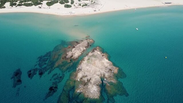 View with the drone of the beach of Chia (sardinia)  with the lagoon behind and green hills in the background