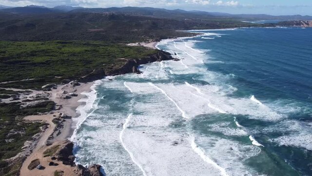 picturesque scenery with waves running into the breathtaking bay of rena majore in sardinia, wonderful weather