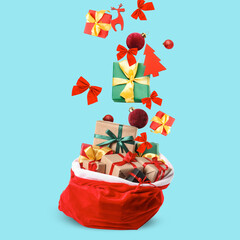Santa Claus bag with falling gifts and Christmas decorations on blue background