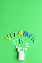 Text VITAMIN B with pills on color background