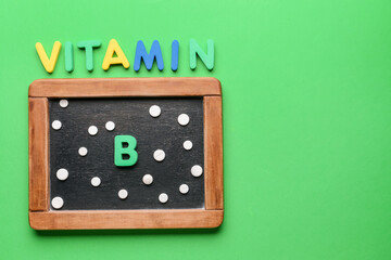 Text VITAMIN B with pills and chalkboard on color background