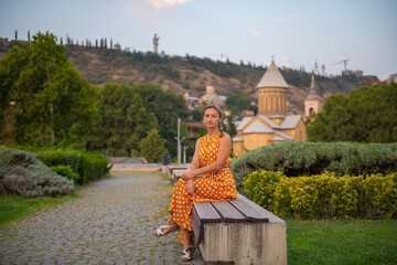 a woman is sitting on a bench in tbilisi
