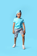 Cute dancing African-American boy on color background
