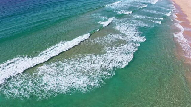 Ocean beach in Australia. Long white sand coast and sea waves aerial view