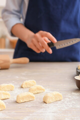 Uncooked dumplings on light wooden table
