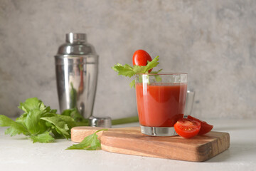 Board with glass of bloody mary on table