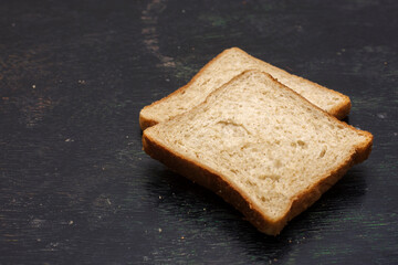 Two slices of bread on a black background