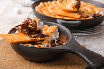 Frying pan with tasty S'mores dip on table, closeup - obrazy, fototapety, plakaty