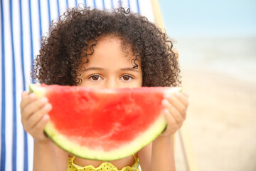 African-American little girl with watermelon on sea beach
