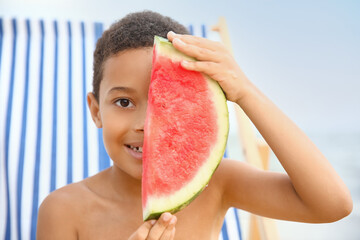African-American little boy with watermelon on sea beach