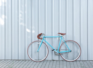 Stylish bicycle near light blue wall