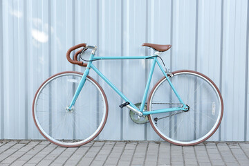 Stylish bicycle near light blue wall