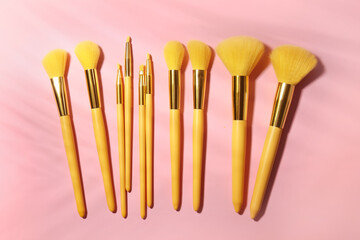 Set of stylish makeup brushes on pink background
