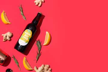Bottle of fresh kombucha with ginger and lemon on color background