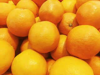 Fresh orange fruit pile on stall in supermarket