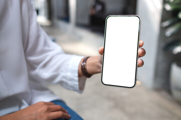 Mockup image of a woman holding and showing mobile phone with blank desktop screen