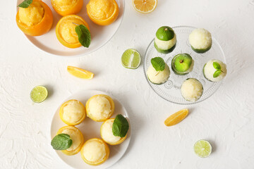 Plates with tasty ice creams in citrus fruit peels on light background - obrazy, fototapety, plakaty