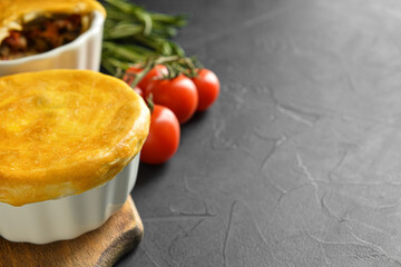 Tasty vegetable pot pies on black background, closeup
