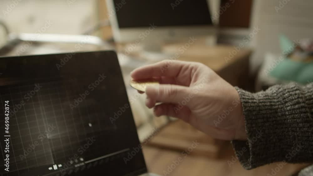 Poster trader checking bitcoin chart and holding coin in hand, crypto concept
