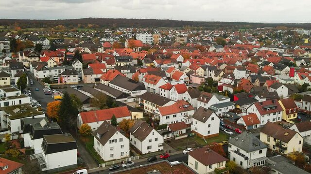 Aerial, residential houses with traditional red tile roofs in Dietzenbach, Germany, cinematic tilt down dolly in, epic 4K