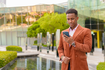 Portrait African businessman outdoors using mobile phone