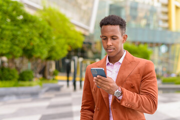 Portrait African businessman outdoors using mobile phone