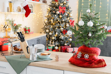 Small Christmas tree on table top in interior of light kitchen