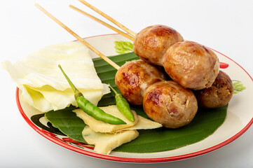 Isan sausage with side dishes fresh chili, fresh ginger, Cabbage.
Place in a serving dish. isolated on white background.