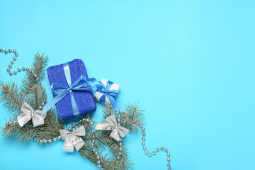 Composition with Christmas gift boxes and fir branches on blue background