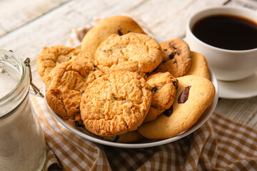Bowl with tasty homemade cookies with chocolate chips on white wooden background