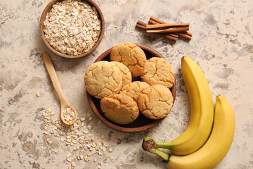 Bowl with tasty homemade oatmeal cookies on beige background